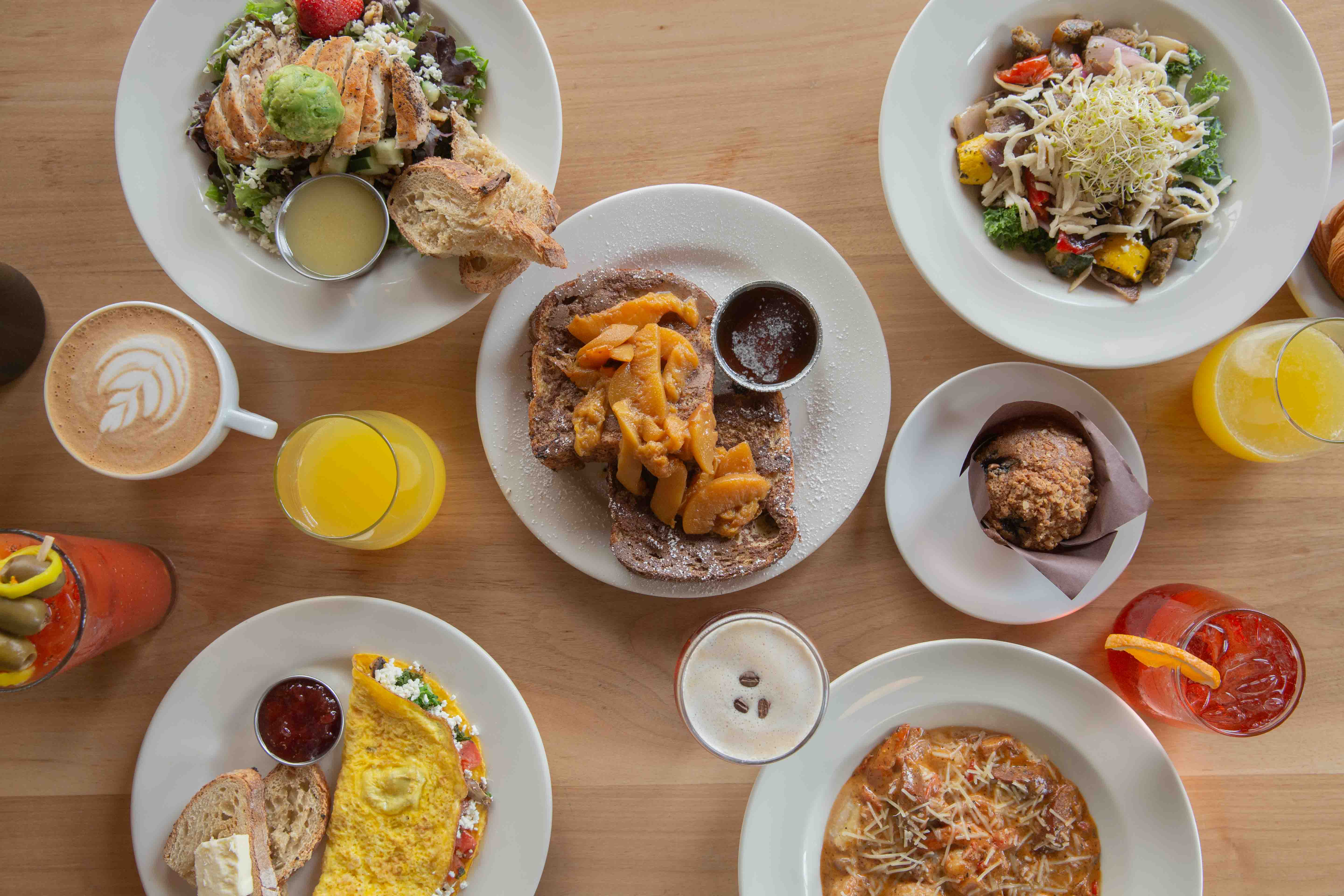 Overhead view of breakfast and brunch on a table with mimosas, bloody mary and coffee